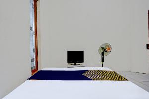 een kamer met een bed met een computer erop bij OYO LIFE 92077 Tarlo Guest House 3 in Pradahkalikendal