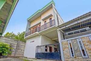 een gebouw met een balkon erboven bij OYO LIFE 92077 Tarlo Guest House 3 in Pradahkalikendal