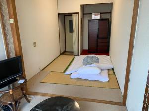 a small room with a bed and a tv at Beppu no Oyado Kagaya in Beppu