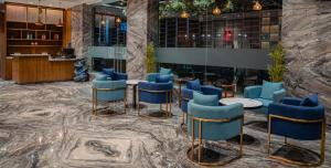 a lobby with blue chairs and tables and a counter at Lords Inn Rajkot in Rajkot