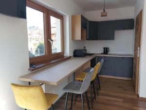 cocina con sillas amarillas y encimera en Topór Apartament widokowy z placem zabaw en Kościelisko