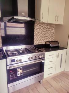 a kitchen with a stove and a microwave at Peace of Mind Holiday Home in Amanzimtoti