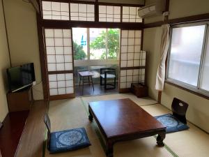a room with a table and chairs and a tv at Beppu no Oyado Kagaya in Beppu