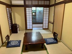 Zimmer mit einem Tisch, 2 Stühlen und einer Tür in der Unterkunft Beppu no Oyado Kagaya in Beppu