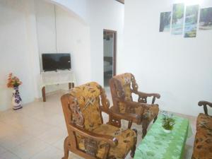 uma sala de estar com duas cadeiras e uma televisão em Sahani Villa em Aluthgama