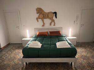 - une chambre avec un lit avec un cheval sur le mur dans l'établissement LB Home, à Termini Imerese