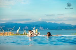 a group of people swimming in the water at D'Lioro Hotel & Resort in Ha Long +50 photos