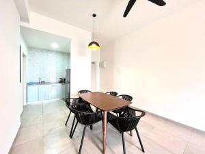 a kitchen and dining room with a wooden table and chairs at Ins Suite @ The Quartz Residence-Infinity Pool in Melaka