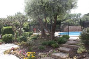 un jardín con piscina, árboles y flores en villa d'exception avec piscine , au bord de la mer en Hyères