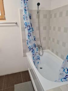 a bathroom with a tub and a shower curtain at Tiny house Floare de colt in Moieciu de Sus