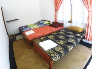 2 łóżka pojedyncze w pokoju z oknem w obiekcie 20 House Villa w mieście Arugam Bay