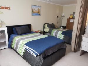 a bedroom with two beds and a dresser at Chrissie's Dongara in Kimba