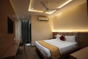 Habitación de hotel con cama y ventilador de techo. en HOTEL SUNRISE HOSPITALITY, en Vijayawāda