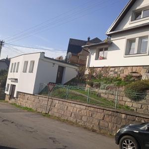 ein weißes Haus mit einem Zaun davor in der Unterkunft Ubytovani u Nadii in Železný Brod