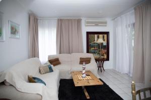 a living room with a white couch and a table at Mamma Mia House in Sandton