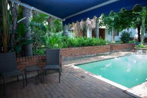 Sandton的住宿－Mamma Mia House，一个带椅子的庭院和一个游泳池
