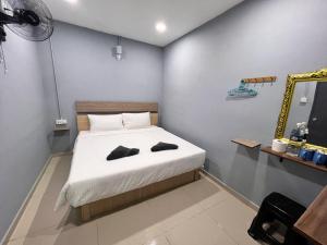 ein Schlafzimmer mit einem Bett mit zwei Schuhen drauf in der Unterkunft Hotel Yasmin in Brinchang