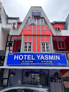 伯恩倉的住宿－Hotel Yasmin，上面有酒店 ⁇ 卡昆标志的红色建筑