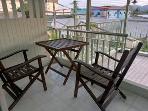 einen Holztisch und zwei Stühle auf dem Balkon in der Unterkunft 168Hostel Airport@Phuket in Thalang