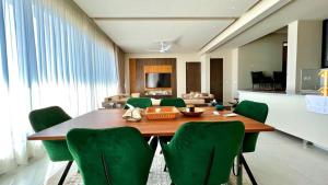 a dining room with a table and green chairs at 2 Bed Royal in Murree