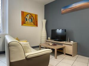 salon z telewizorem, kanapą i stołem w obiekcie Joli appartement climatisé w mieście Périgueux