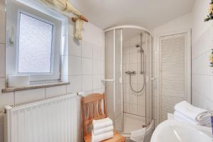 a white bathroom with a shower and a sink at Ferienwohnung " Müritzblick " in Waren