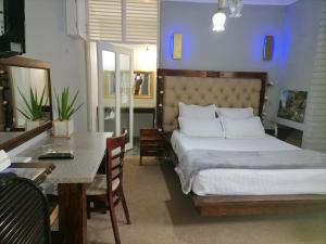 a bedroom with a bed and a table and a dining room at Adirondack Inn in Estcourt +70 photos
