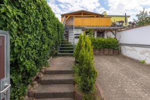 a stairway leading up to a house with a hedge at Ferienwohnung " Müritzblick " in Waren