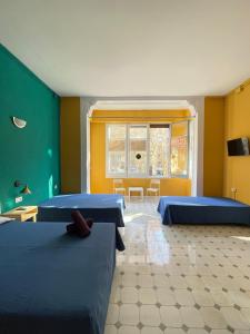 a room with three beds and a table and chairs at Hostel Friends Barcelona in Barcelona