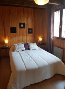 a bedroom with a large white bed with two lamps at Chalet La Campagnette in Eyne
