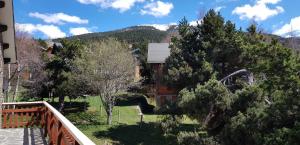 ein Haus mit einem Balkon, Bäumen und einem Berg in der Unterkunft Chalet La Campagnette in Eyne