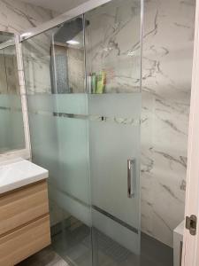 een douche met een glazen deur in de badkamer bij Apartamento entero en La Carihuela a 50 m de la playa in Torremolinos