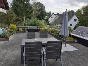 a table and chairs and an umbrella on a patio at Ferienwohnung Mittendrin, Stadtmitte Hermeskeil in Hermeskeil