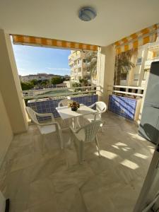 een balkon met een witte tafel en stoelen en een raam bij Apartamento entero en La Carihuela a 50 m de la playa in Torremolinos