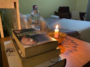un libro sobre una mesa con una vela y una botella en Perfect Travel-Stop Room 3Km From Nanyuki Town - Charell View, en Nanyuki