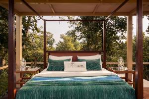 a bed on a screened in porch with two tables at Bagh Tola, Bandhavgarh Tiger Reserve in Tāla