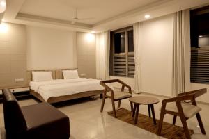 1 dormitorio con cama, sofá y mesa en The Presidential Suites, en Bhuj