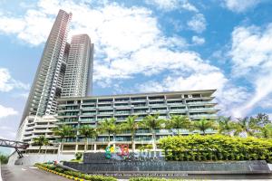 a large building with palm trees in front of it at Geo38 Premium Suites Genting Highlands by BYON in Genting Highlands
