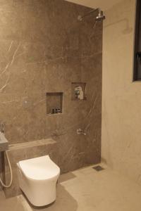 uma casa de banho com um WC e um chuveiro em The Presidential Suites em Bhuj