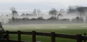 un campo nebbioso con una recinzione di fronte a un campo di Brampton Dales Farm a Gainsborough