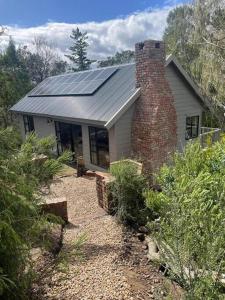 uma casa com painéis solares por cima em Vredenbosch Hoekwil em Wilderness