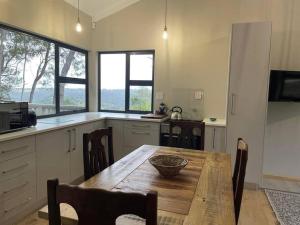 una cocina con una mesa de madera con un tazón. en Vredenbosch Hoekwil, en Wilderness