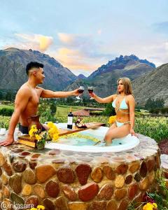 a man and a woman sitting at a table drinking wine at Inkasaire Boutique Lodge in Urubamba