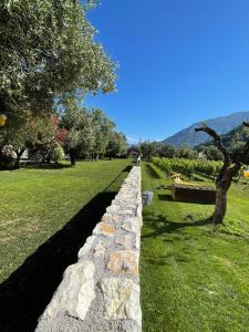 a stone wall in a park with a tree at Residence Verdeblu in Arco
