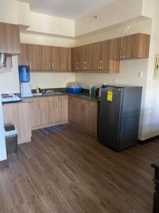 uma cozinha com um frigorífico preto e armários de madeira em Edrose Condo Unit Rental em Baguio