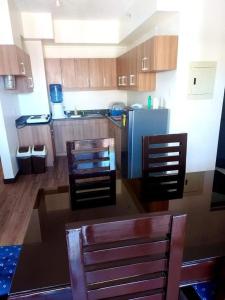 uma cozinha com uma mesa e cadeiras e um frigorífico em Edrose Condo Unit Rental em Baguio