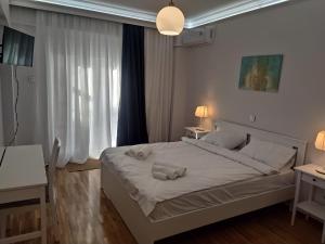 a bedroom with a bed with two towels on it at Athina Pantheon Mitropoleos in Thessaloniki