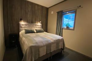a bedroom with a large bed with a window at Modern Stuga med Ski Lodge känsla in Järvsö