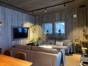 uma sala de estar com dois sofás e uma televisão em Modern Stuga med Ski Lodge känsla em Järvsö