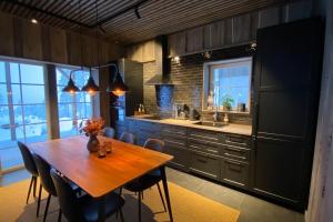 a kitchen with a wooden table and some chairs at Modern Stuga med Ski Lodge känsla in Järvsö